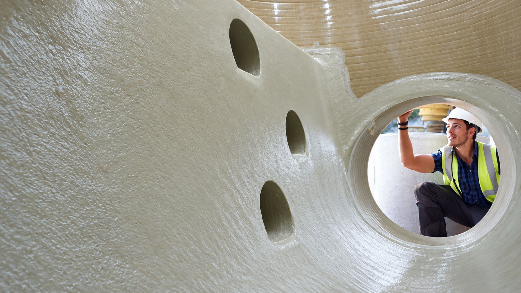 An employee is inspecting the quality of a bespoke GRP tank.