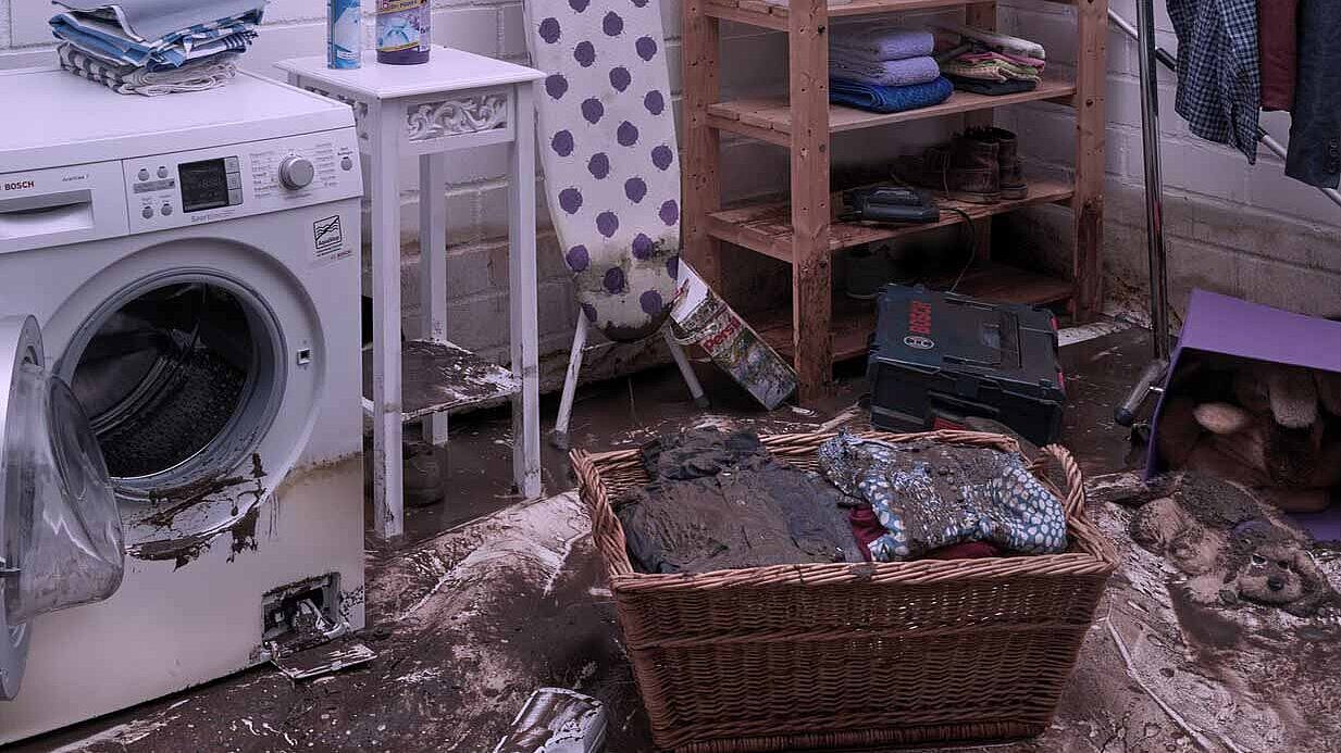 Laundry room with a dirty laundry basket and a washing machine.