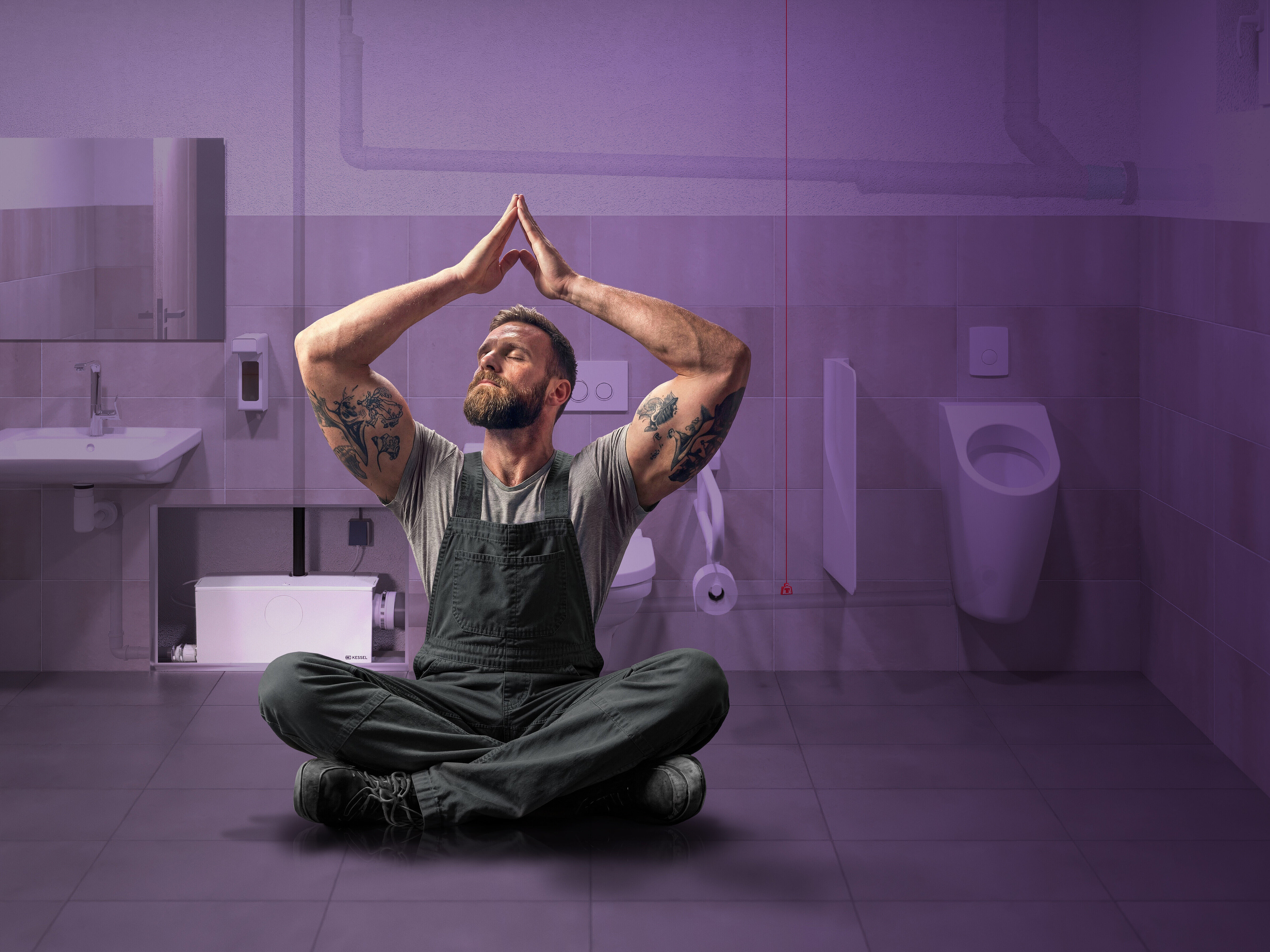 A relaxed tradesman in a commercial toilet, with a double flush system in the background.